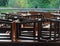 Restaurant on raft by canal in countryside with black wooden and metal chairs put on brown wooden tables