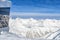 Restaurant or residential building on top of austrian alpine mountain peaks covered with snow layer in winter at bright cold