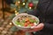 Restaurant services. Waitress with food dish serving vegetable salad in restaurant.