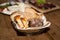 Restaurant serving of assortment of bread on napkin in basket with other dishes of background