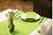 Restaurant table setout with white plates, silverware and green decoration