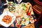 Restaurant table setting with food outdoor on the street. Italian pasta spaghetti, glass of red wine, mozarella cheese, bread, sa