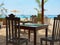 Restaurant tables against the backdrop of the ocean, ships, palm trees and beautiful white sand. Beach vacation and travel concept
