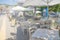 Restaurant tables and chairs below sunshades on the terrace on the seashore. Blurred scene of the restaurant in Neos marmaras,