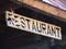 Restaurant. Vintage looking inscription carved in wood.