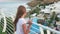 Resting girl looking from outdoor balcony on swimming pool and sea panorama. Tourist girl watching from terrace on