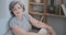 Resting smiling elderly woman reclining on a comfy sofa stretching, calm, meditating