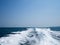 Restless foamy blue sea wake water on the sea water surface with clear blue sky while travel by speed boat in the ocean