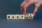 Restless or restful symbol. Businessman turns wooden cubes, changes the word `restless` to `restful`. Beautiful grey table, gr