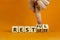 Restless or restful symbol. Businessman turns wooden cubes, changes the word `restless` to `restful`. Beautiful orange table,