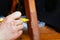 Restoration and repair of wooden furniture the master hand closes the scratch with a special marker close-up