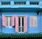 A restored blue Chinese peranakan shop house with pink shutters