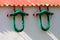 Restored and freshly painted colorful old vintage retro farming equipment used as garden decoration mounted on white backyard wall