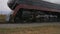 Restored steam locomotive passing by with passenger car blowing smoke and steam thru countryside