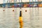 Restrictive buoy at sea against the background of the cargo port