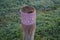 A restrictive roadside pole decorated with knitwear against a background of grass with hoarfrost in November. Berlin, Germany