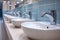 Restroom setting modern interior with a row of white ceramic sinks