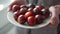 Retail and business concept, ripe black tomatoes on a plate in the hands of a woman.