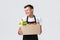 Retail, grocery shopping and delivery concept. Silly cheerful salesman in store packing order for couriers, holding box