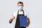 Retail store, shopping during covid-19 and social distancing concept. Cheerful handsome salesman in medical mask and