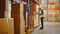 Retail Warehouse full of Shelves with Goods in Cardboard Boxes, Male Worker Scans and Sorts Packag