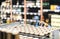 Retail worker filling shelf with drinks in grocery store or customer taking can of beer or soda.