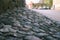 Retaining wall and pavement made of granite cobblestones in a European city. perspective street view