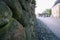 Retaining wall and pavement made of granite cobblestones in a European city. perspective street view