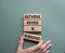 Rethink Revise and Rebrand symbol. Wooden blocks with words Rethink Revise and Rebrand. Businessman hand. Beautiful grey green
