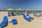 Rethymno, Island Crete, Greece, - July 1, 2016: City beach with people and blue daybeds with green umbrellas