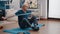 Retired adult pulling resistance band and sitting on yoga mat