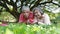 Retired couple holding hearts showing lasting love together in a shady garden.