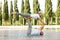 Retired couple of husband and wife performing advanced partner yoga pose in city park on sunny morning