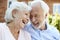 Retired Couple Sitting On Bench And Talking In Assisted Living Facility