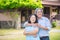 Retired couple standing in front of their house and smile