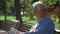 Retired elderly man relaxing outdoors reading a book enjoying retirement