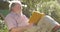 Retired elderly man relaxing outdoors reading a book enjoying retirement