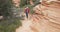 Retired elderly woman walking inside red canyon in Zion Utah