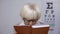 Retired female in spectacles reading book, unhappy with poor vision, problem