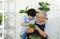 A retired grandfather teaches his grandson to look at the characteristics of plants in pots. Relaxing atmosphere on vacation at