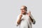 Retired Indian old man eating ice cream, standing icolated against white background