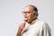 Retired Indian old man eating ice cream, standing icolated against white background