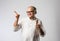 Retired Indian old man eating ice cream, standing icolated against white background