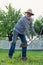 Retired man digging ground near his cottage house