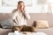 retired man with mental illness touching head while sitting on sofa.