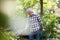 Retired man watering plants in the garden