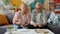 Retired man and woman counting money reading financial document at home