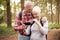 Retired Senior Couple Hiking In Woodland Countryside Taking Photo With Mobile Phone