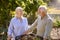 Retired Senior Couple Working In Vegetable Garden Or Allotment Carrying Tray Of Beets