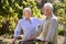 Retired Senior Couple Working In Vegetable Garden Or Allotment Carrying Tray Of Beets